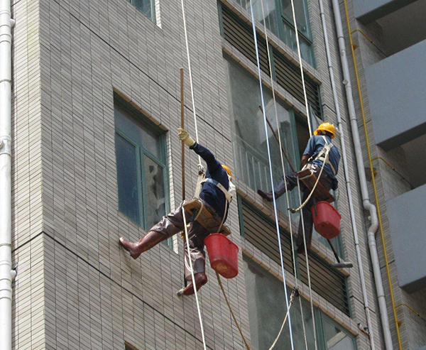 青岛保洁公司作业时,屋顶和地面都有人监护,并用步话机保持联系